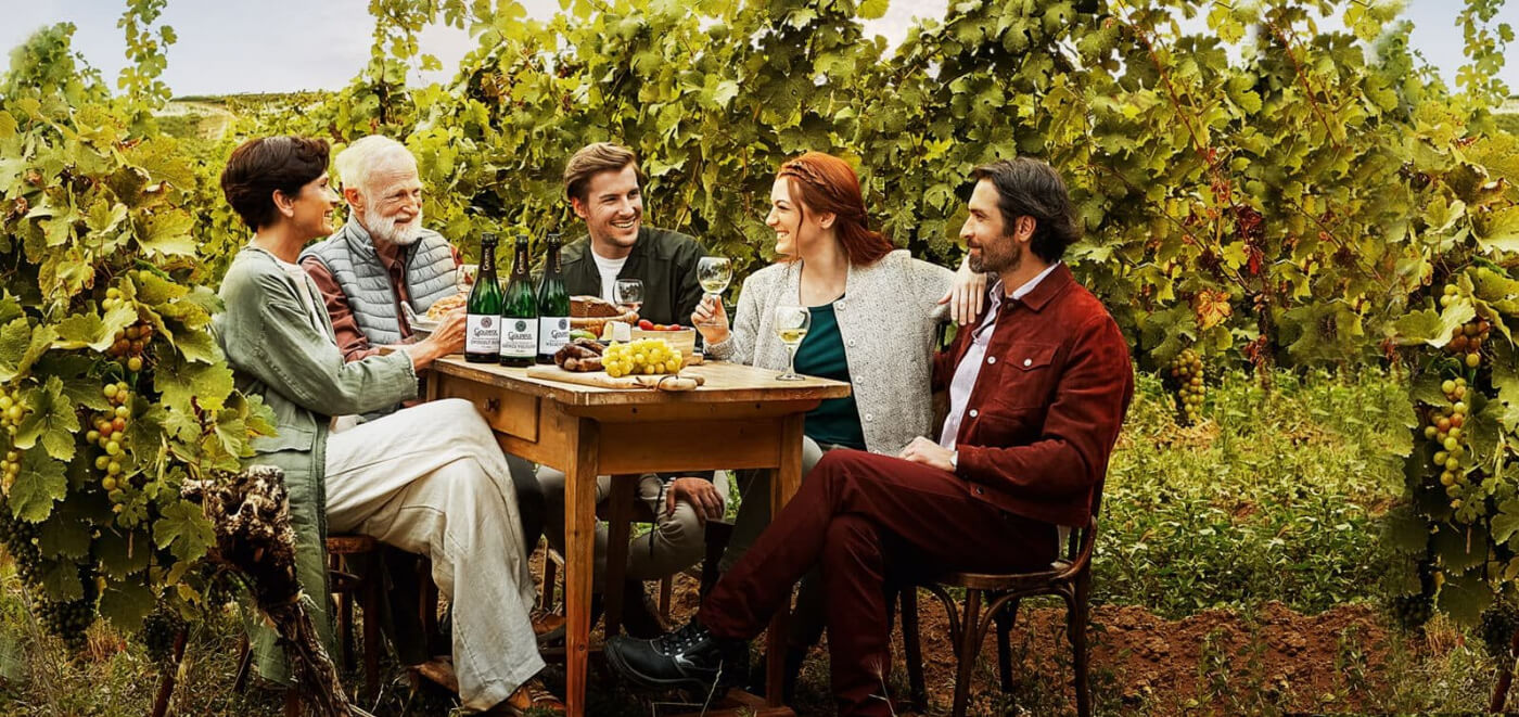 Gruppe beisammen im Weingut bei einer Flasche Goldeck