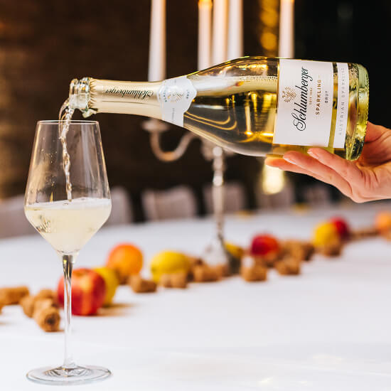 Schlumberger Sparkling Brut Flasche beim Einschenken auf dekoriertem Herbsttisch in den Kellerwelten