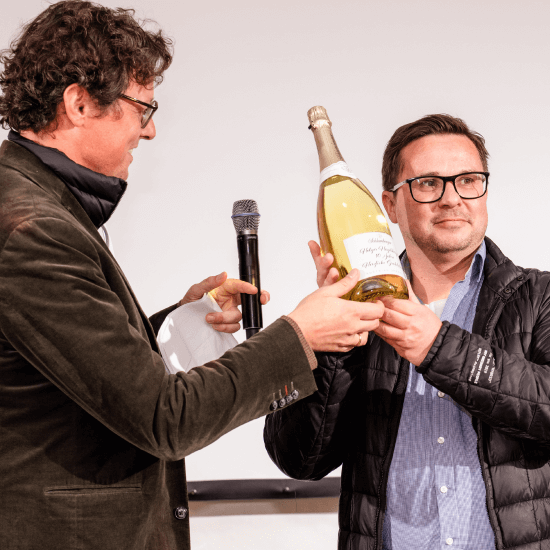 Übergabe einer Flasche Schlumberger auf einer Bühne