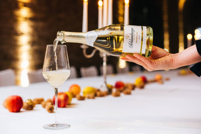 Flasche Schlumberger Sparkling Brut beim Einschenken in der Wiener Sektkellerei.