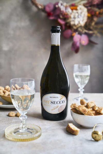 Hochriegl Oh'Secco Bianco 0,7l mit Gläser auf gedeckten Tisch
